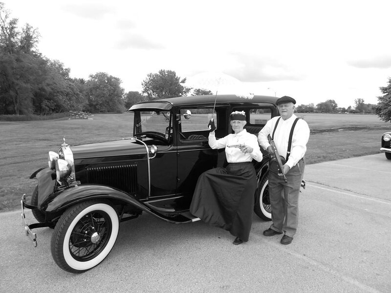 Couple with vintage car and guns