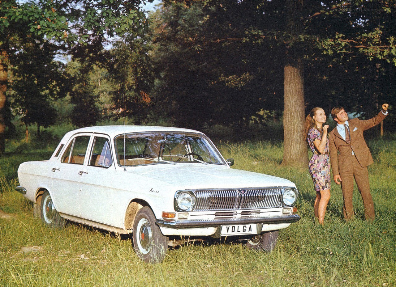 Couple with white car in field