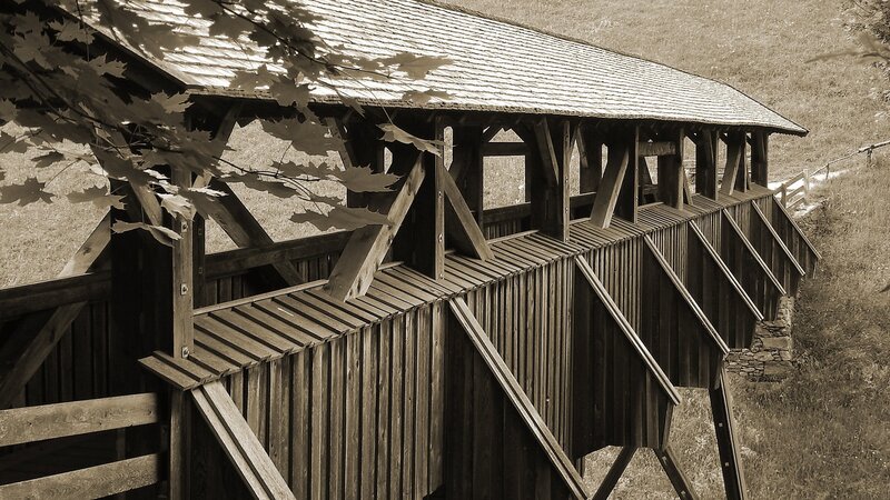 covered wooden bridge in sepia