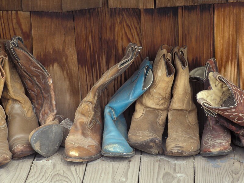 Cowboy boots lined up on a porch