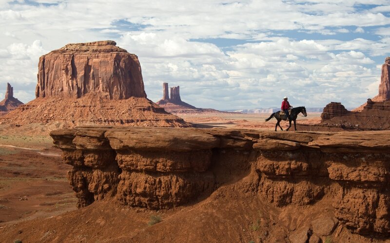 Cowboy on horseback in desert