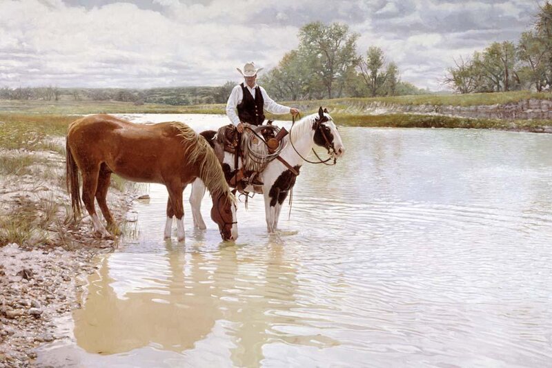 Cowboy with horses at river