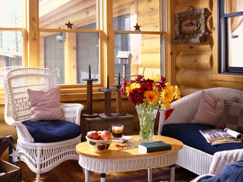 Cozy cabin sunroom with wicker furniture