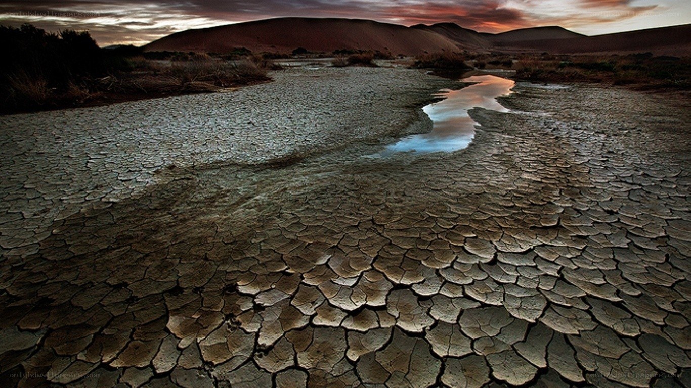 Cracked desert riverbed at sunset