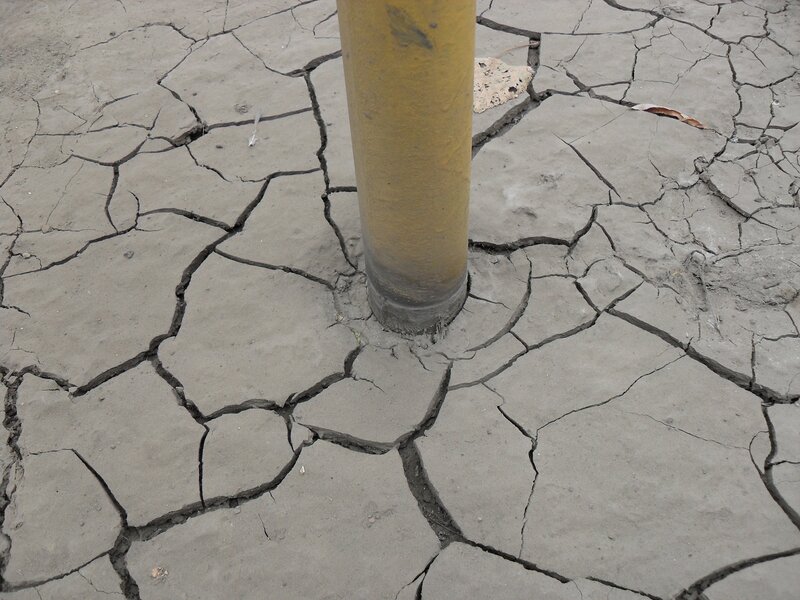Cracked dry ground around a pole