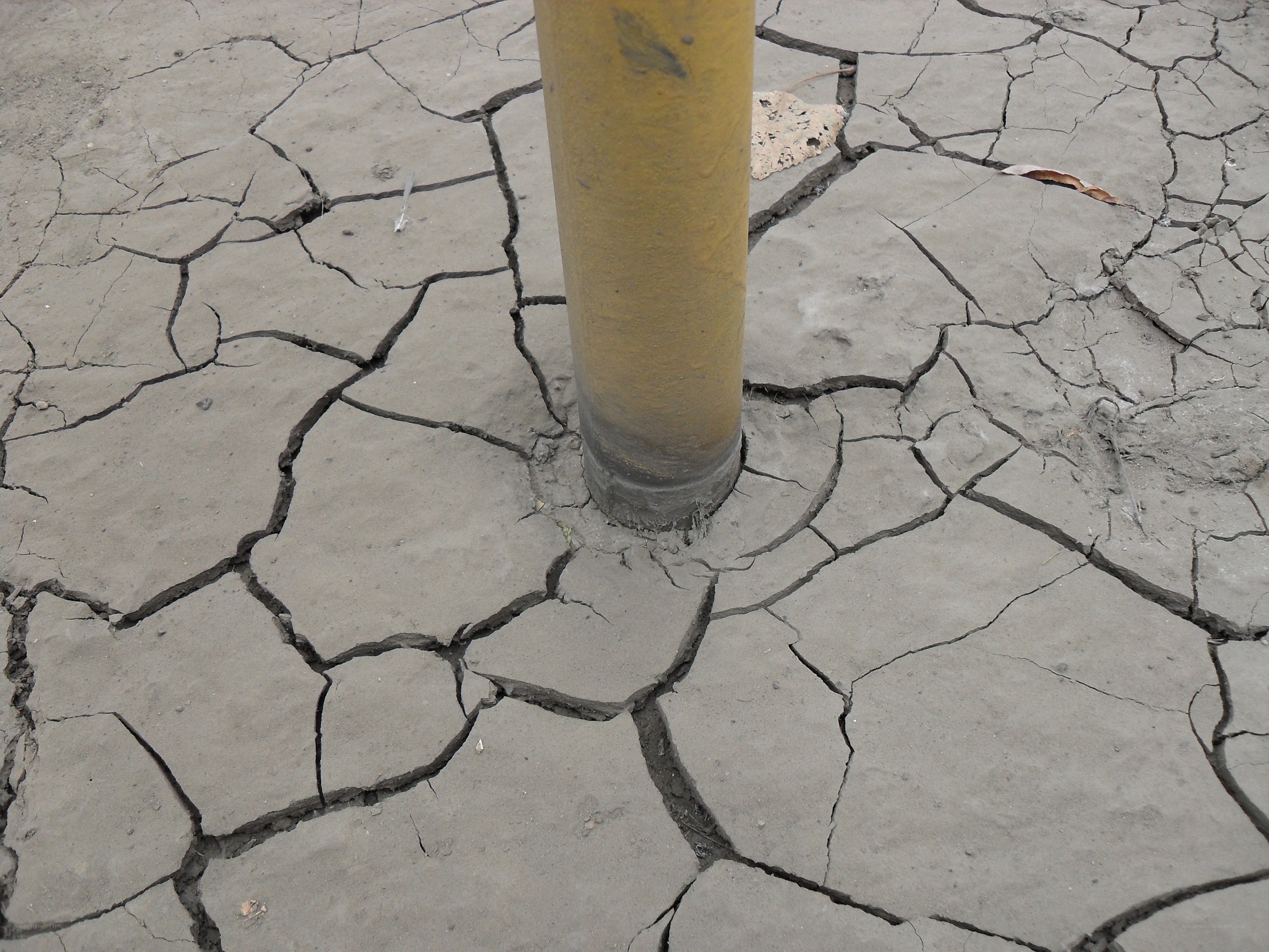 Cracked dry ground around a pole