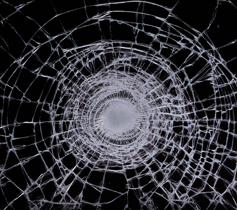 cracked glass with bullet hole