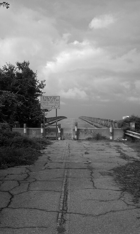 Cracked pavement leads to a bridge