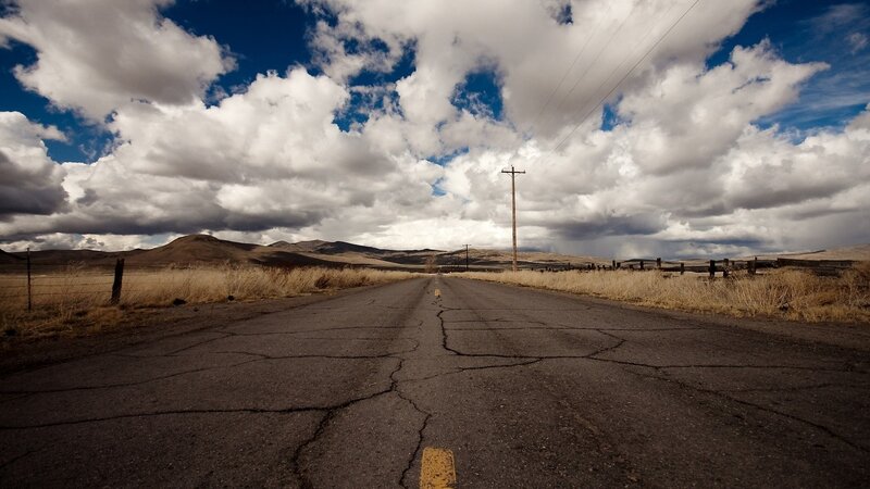 Cracked road under cloudy sky