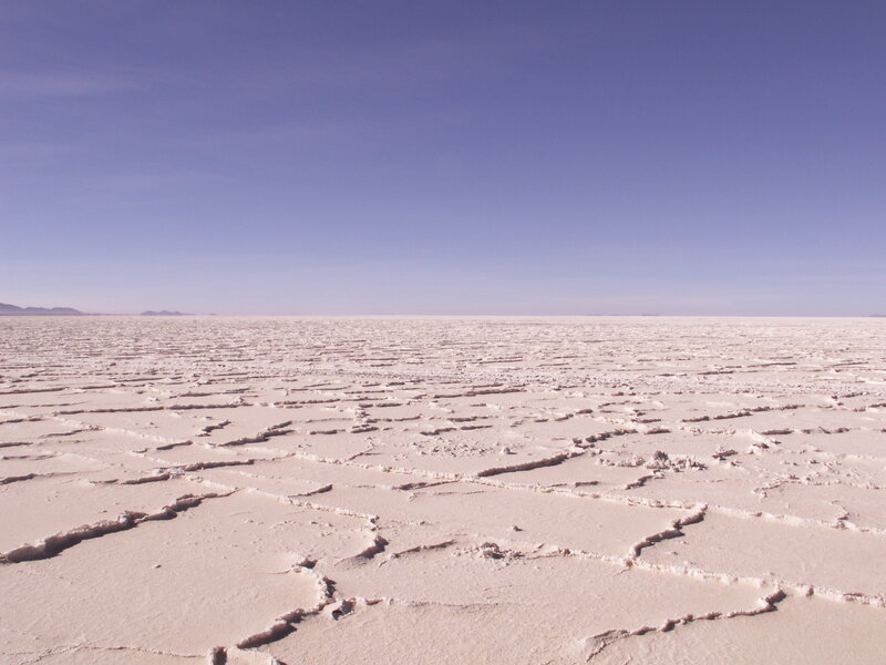 cracked salt flat under blue sky