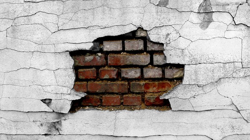 cracked wall with brick hole