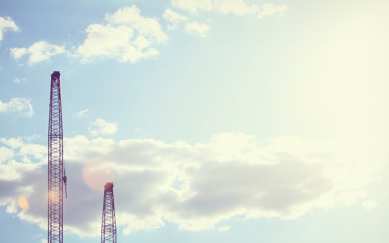 Crane towers against sky