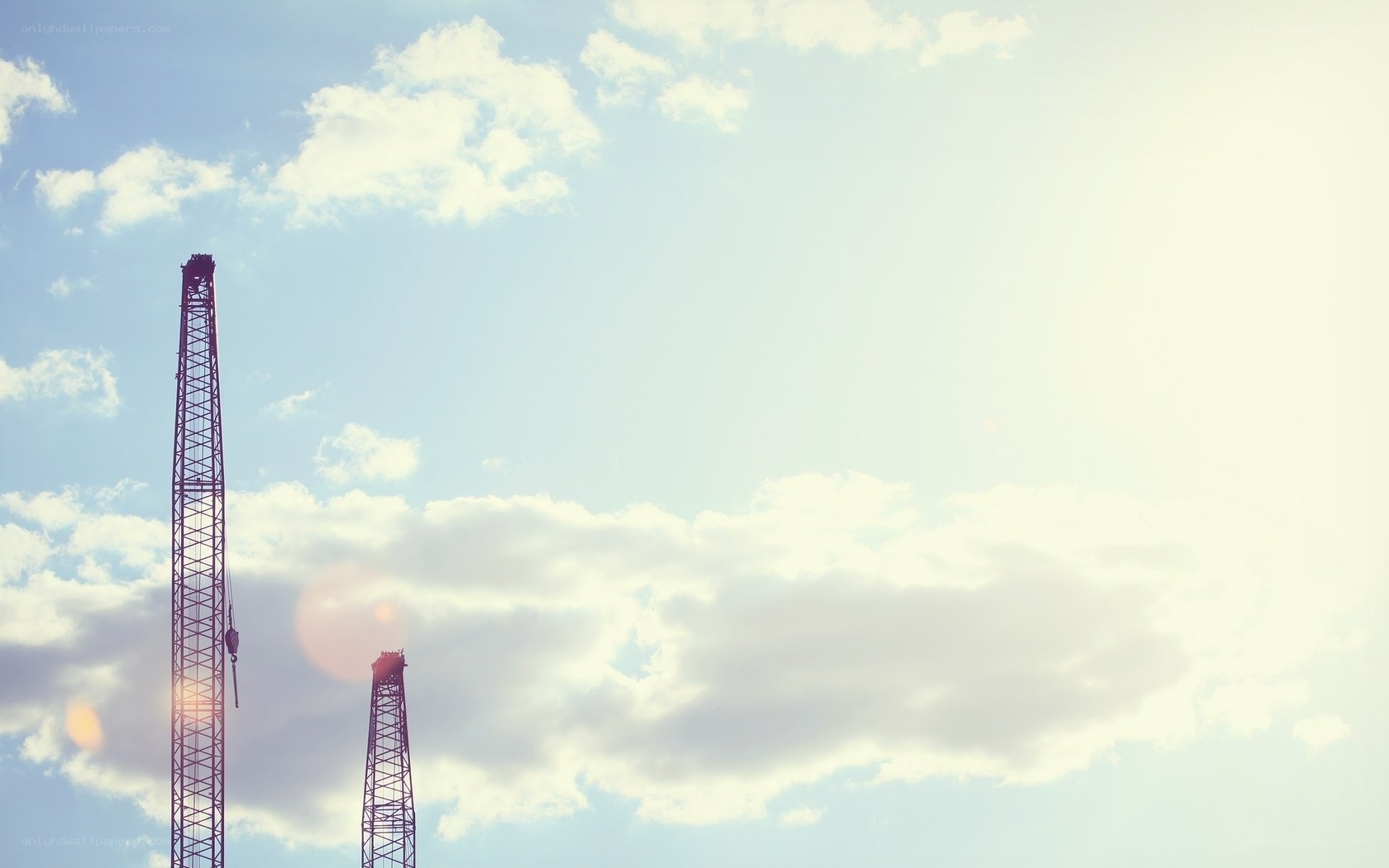 Crane towers against sky