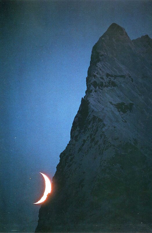 Crescent moon behind mountain