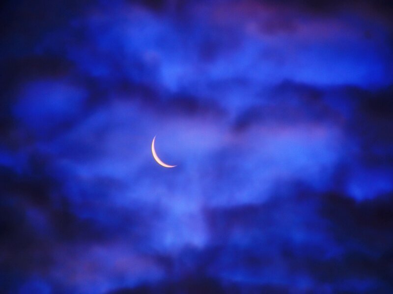 Crescent moon in cloudy sky