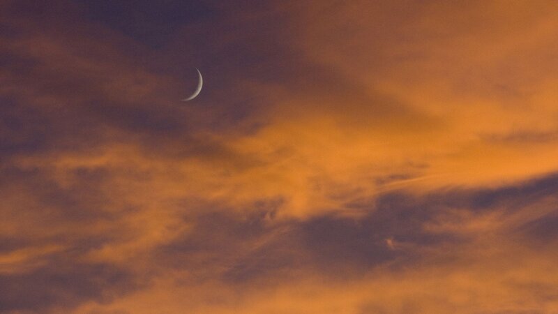 Crescent moon in sunset sky