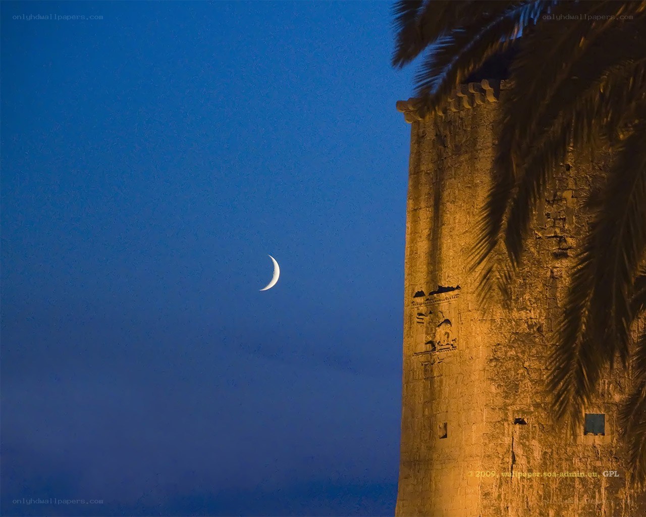 Crescent moon over ancient tower
