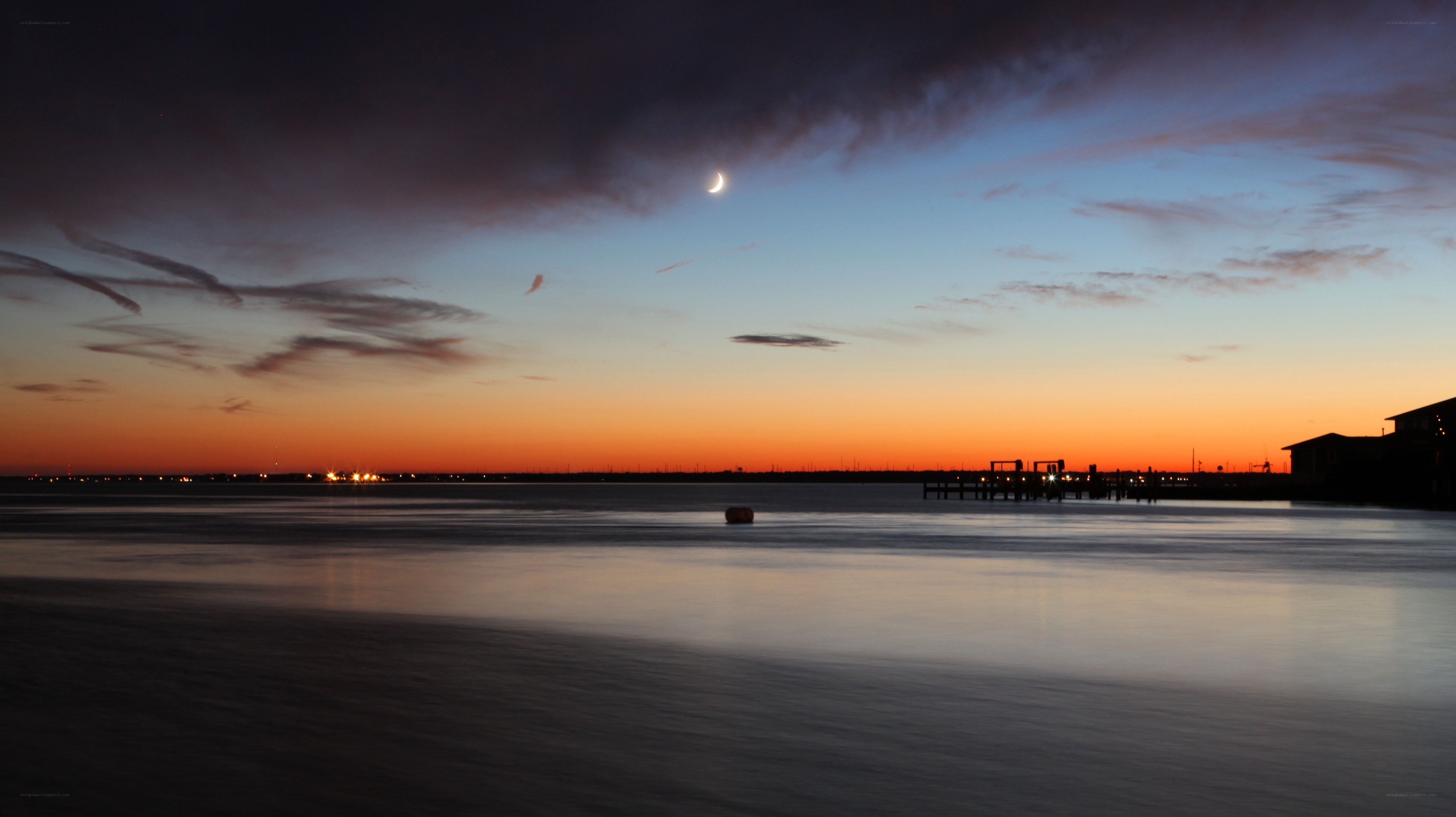 Crescent moon over calm water