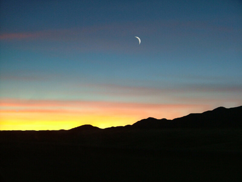 Crescent moon over mountains