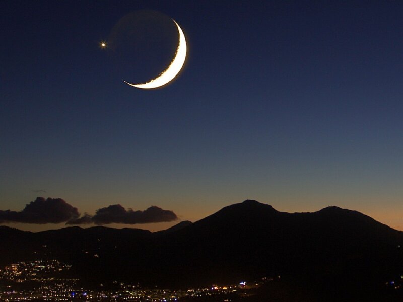 Crescent moon over mountains