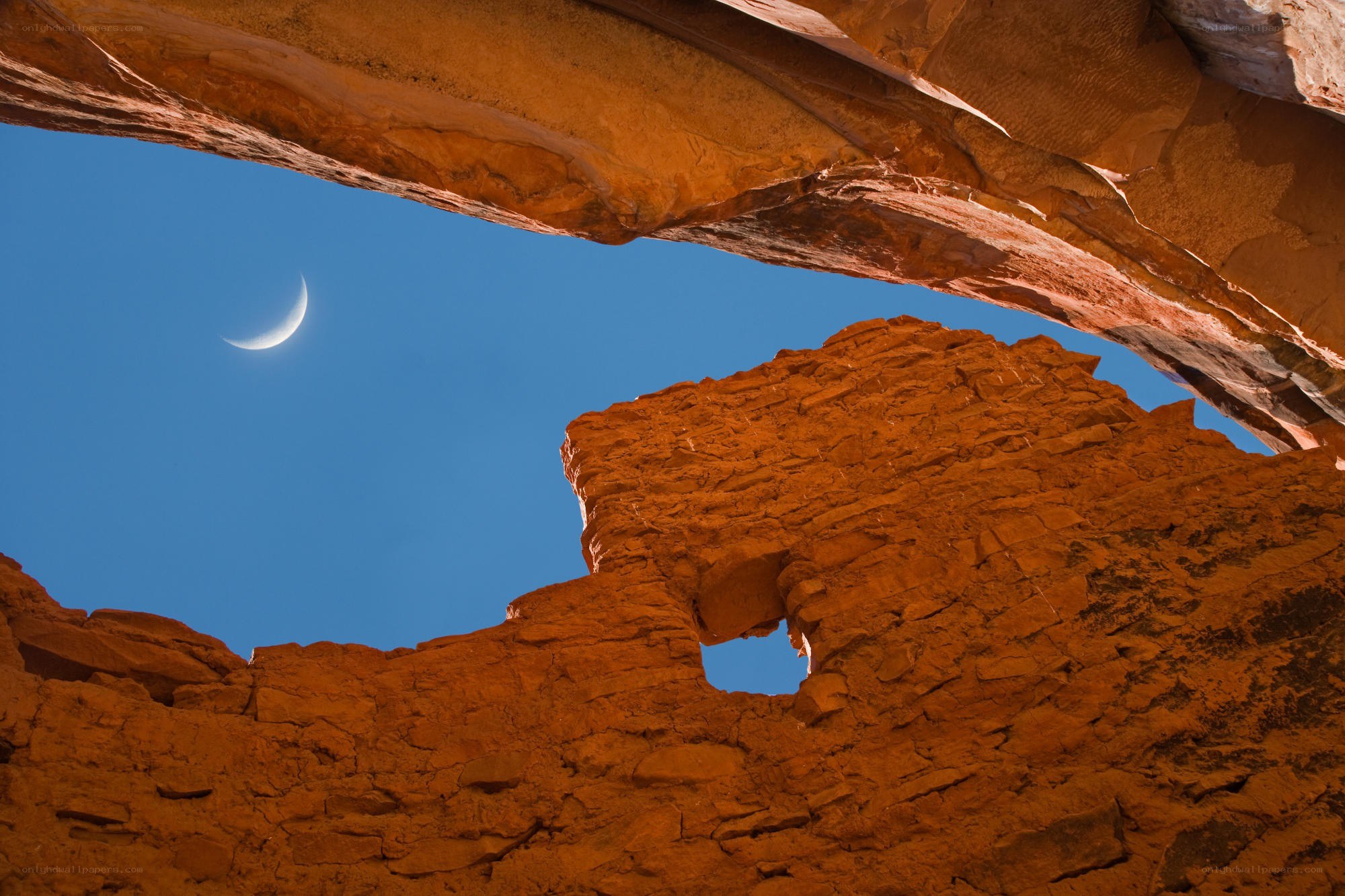Crescent moon over rock arch