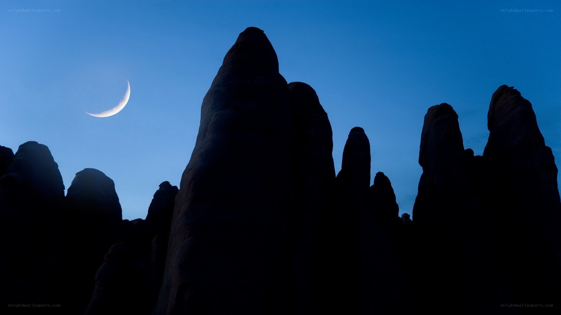 Crescent moon over rock formations