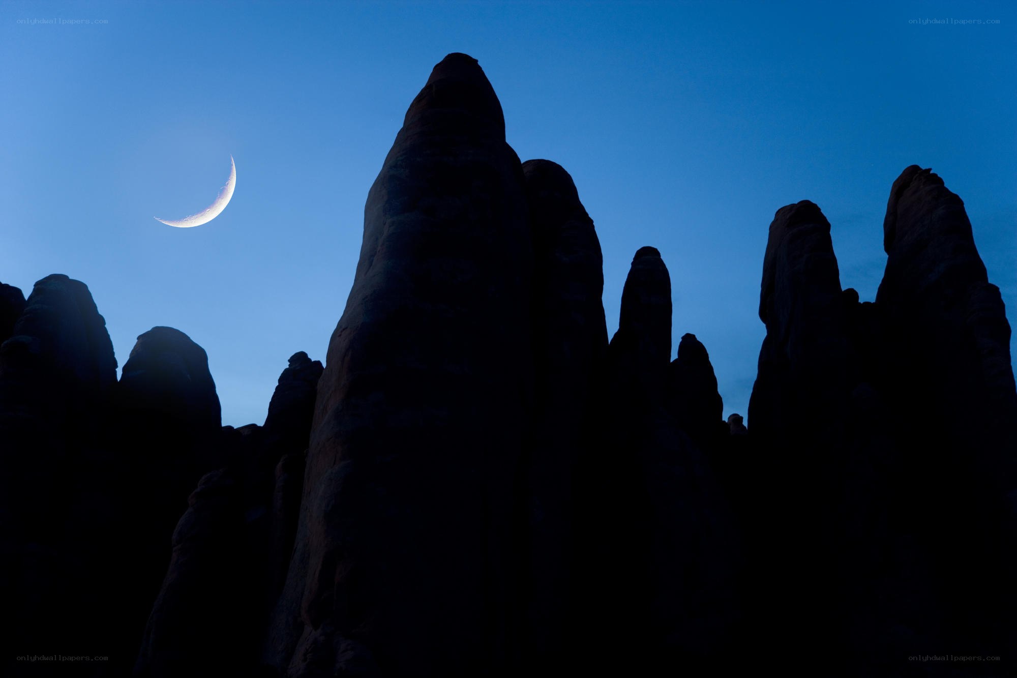 Crescent moon over rock formations