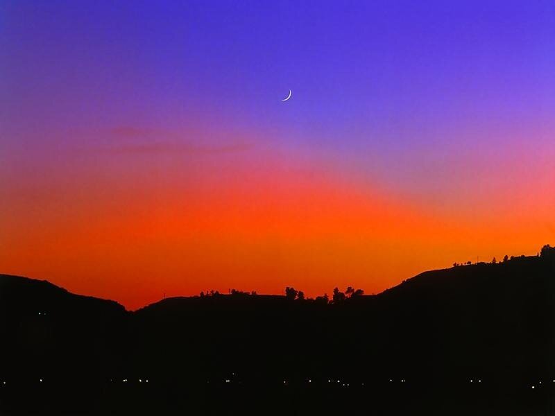 Crescent moon over sunset hills