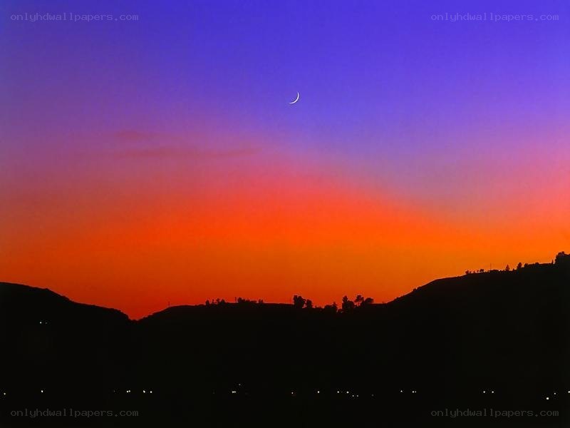 Crescent moon over sunset hills
