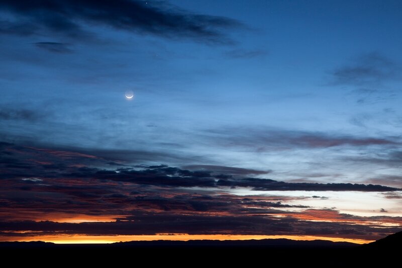 Crescent moon over sunset