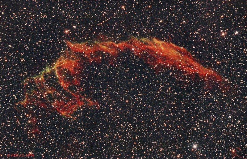 Crescent-shaped nebula in starfield