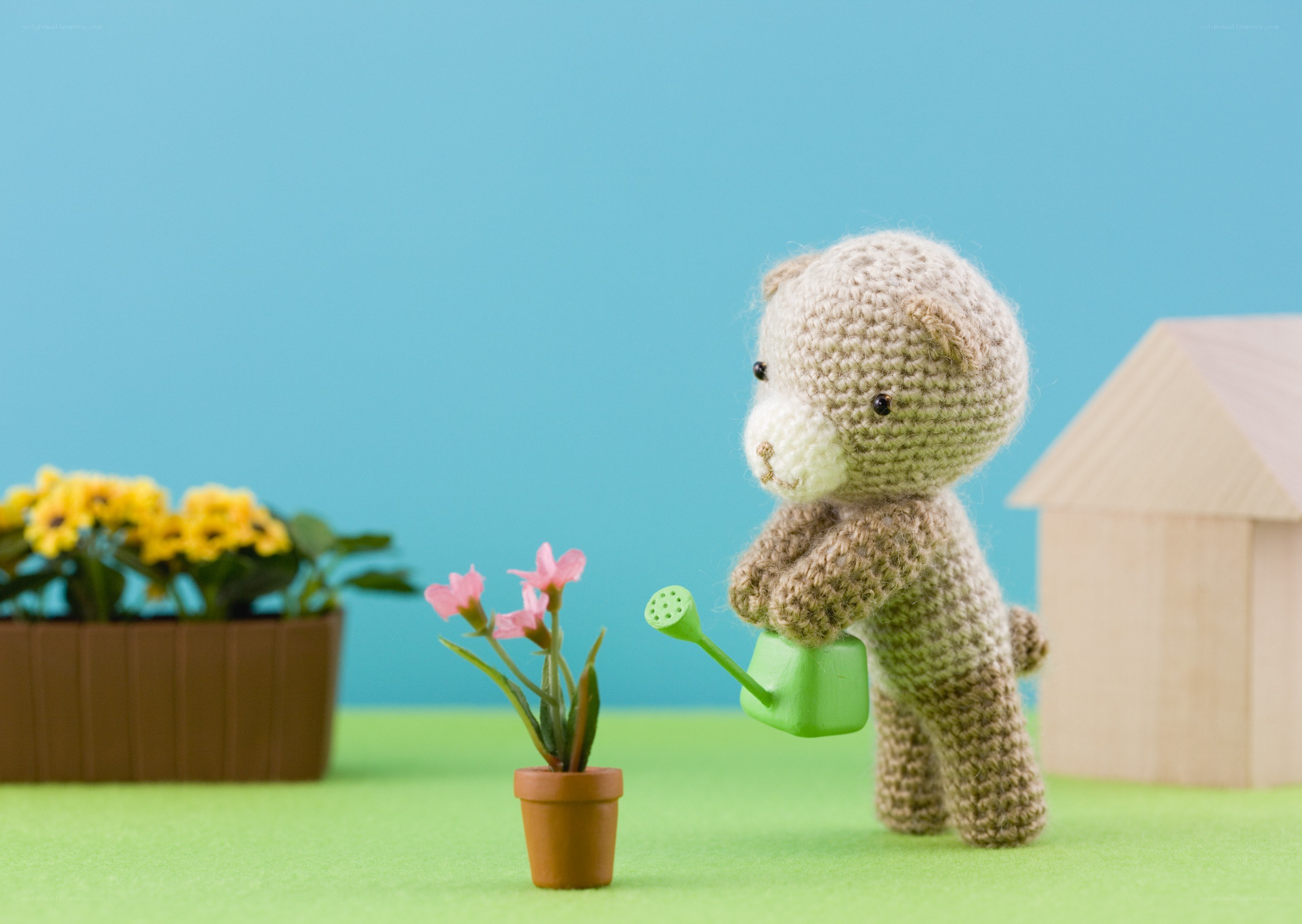 crochet bear watering flowers