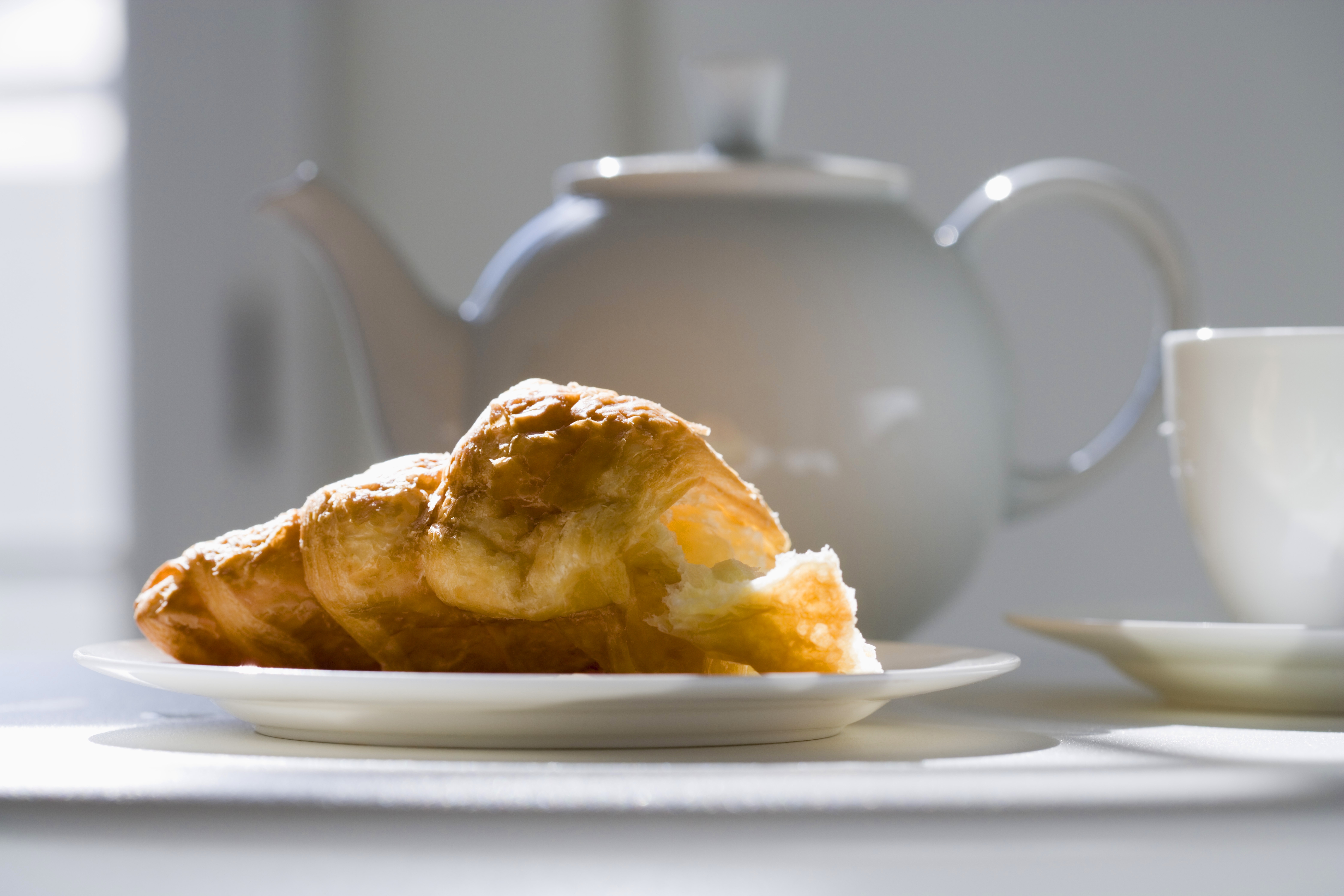 croissant and teapot on table
