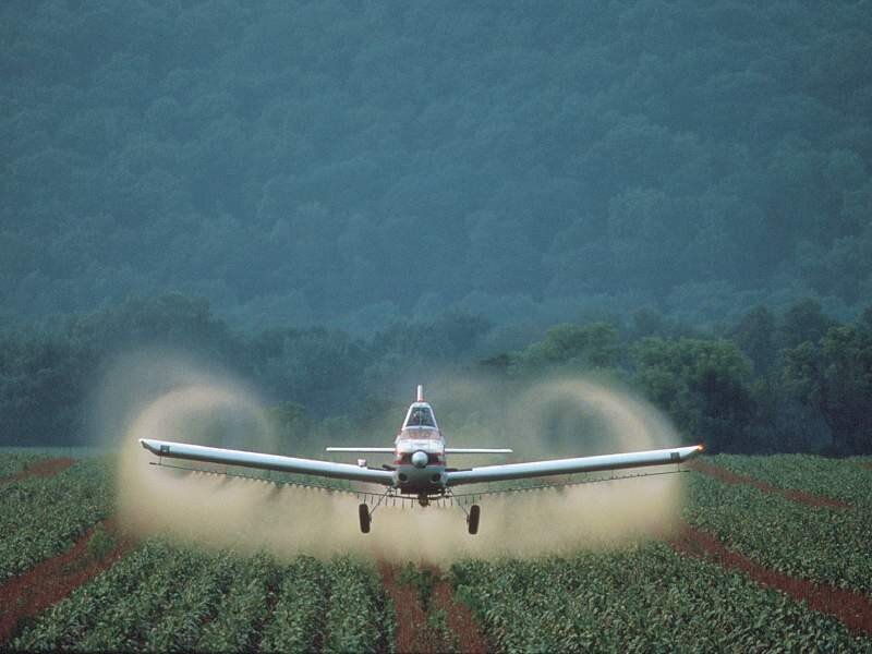 Crop-dusting plane over farmland