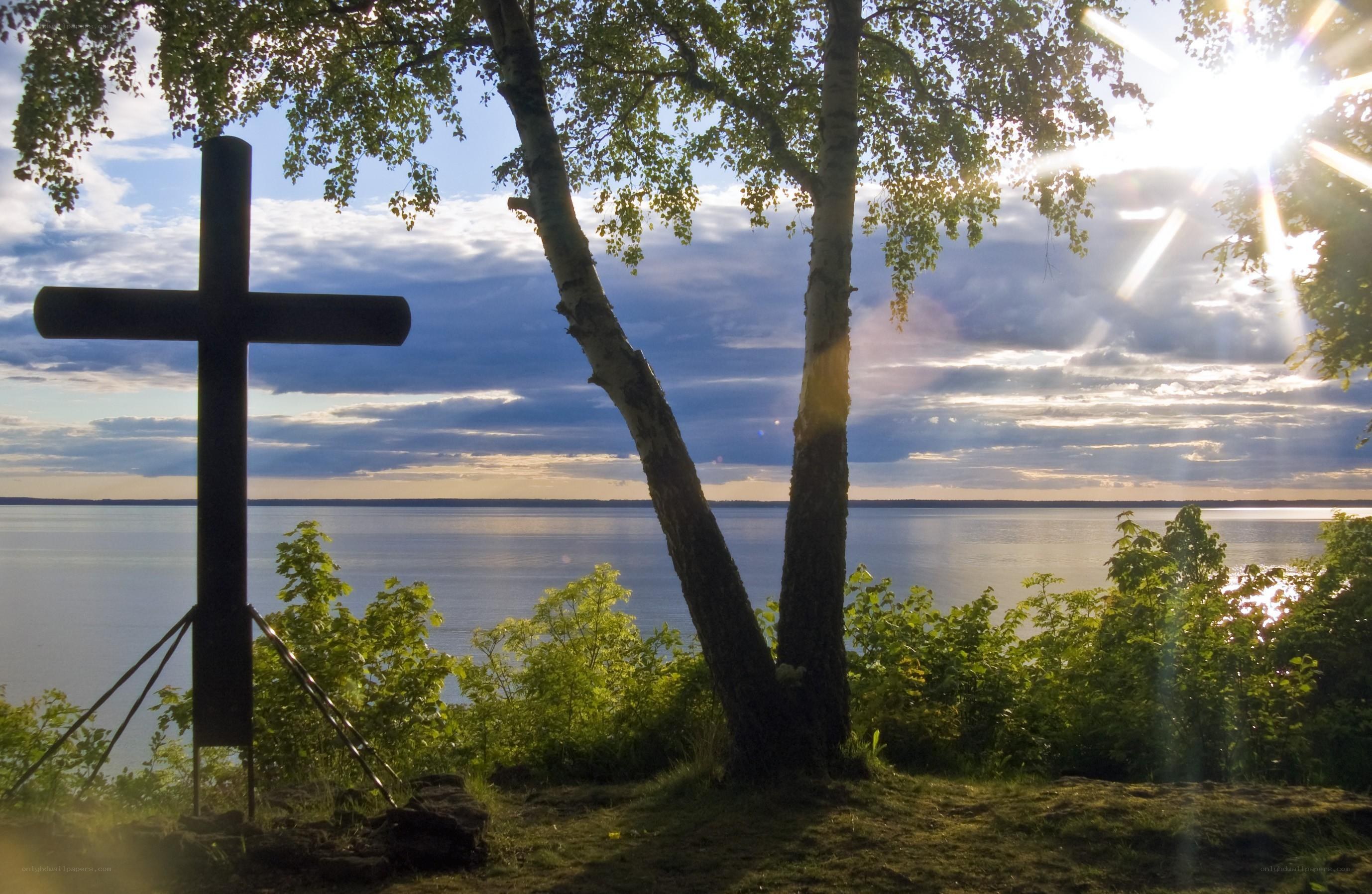 Cross by the lake at sunset