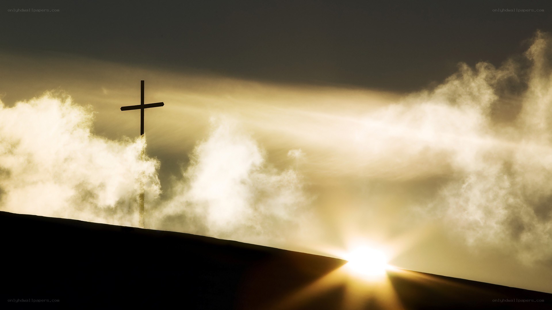 Cross silhouetted against sunrise
