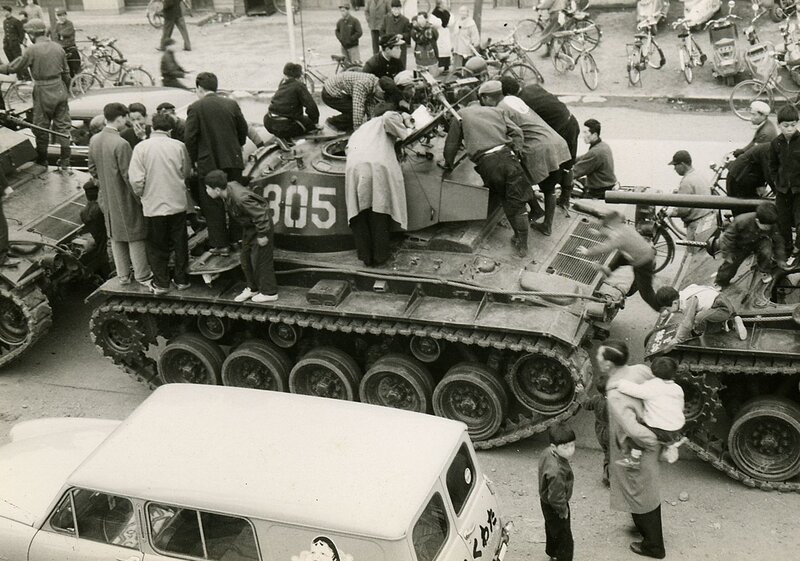 Crowd around military tanks
