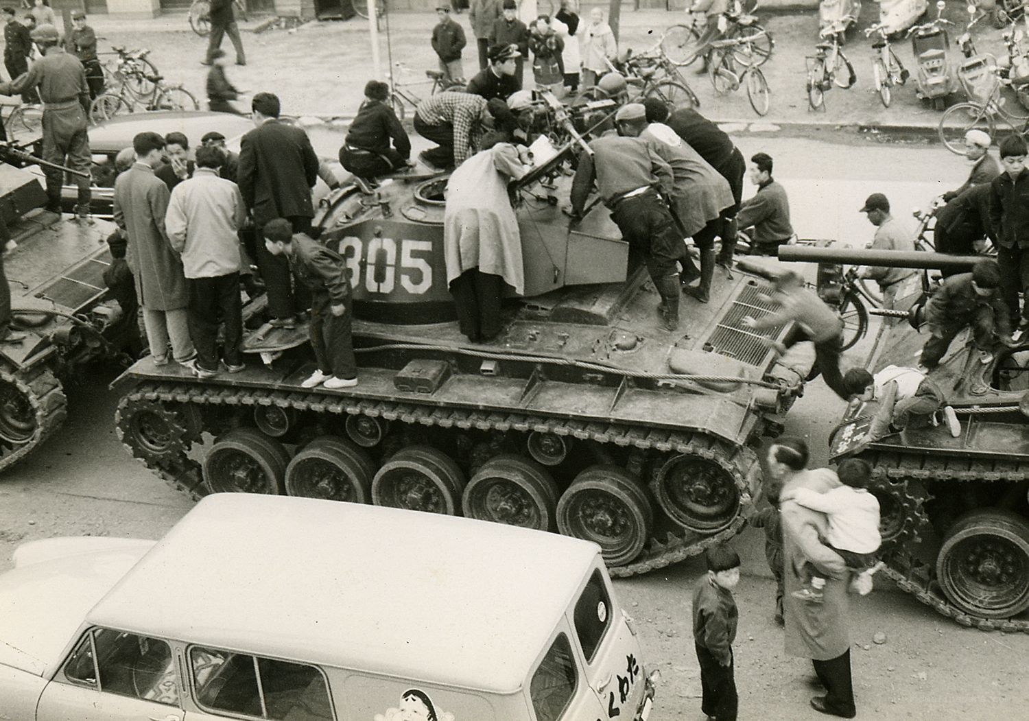 Crowd around military tanks