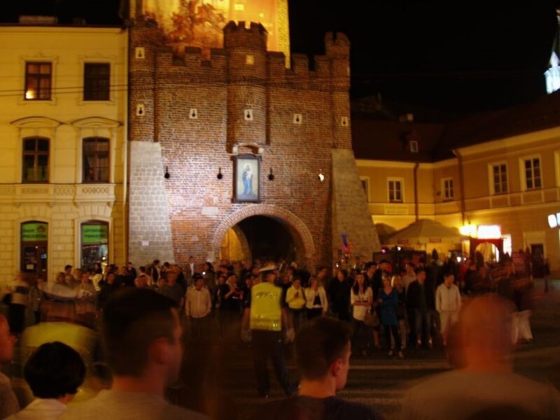 Crowd at night by a historic gate