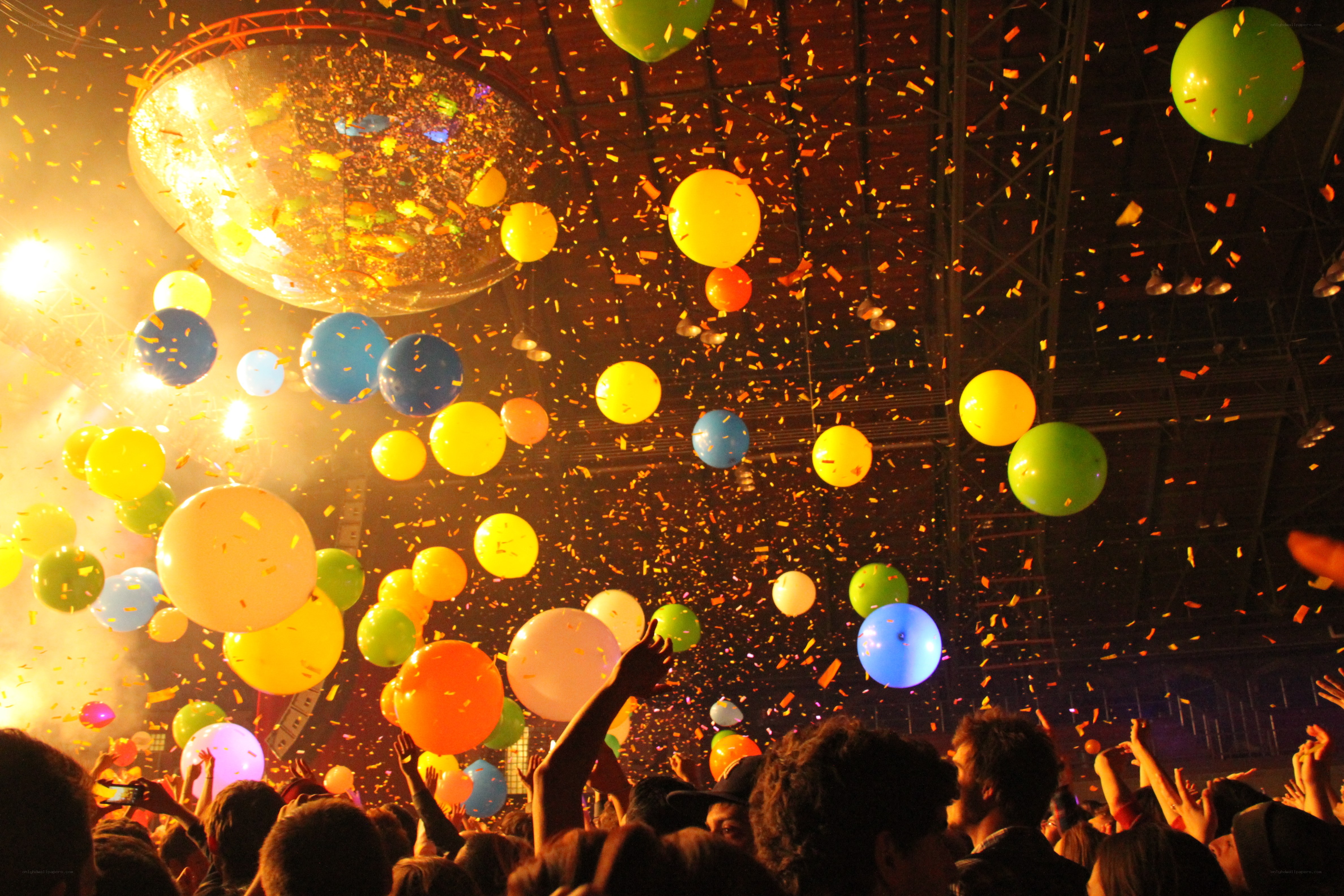 Crowd celebrating with balloons and confetti