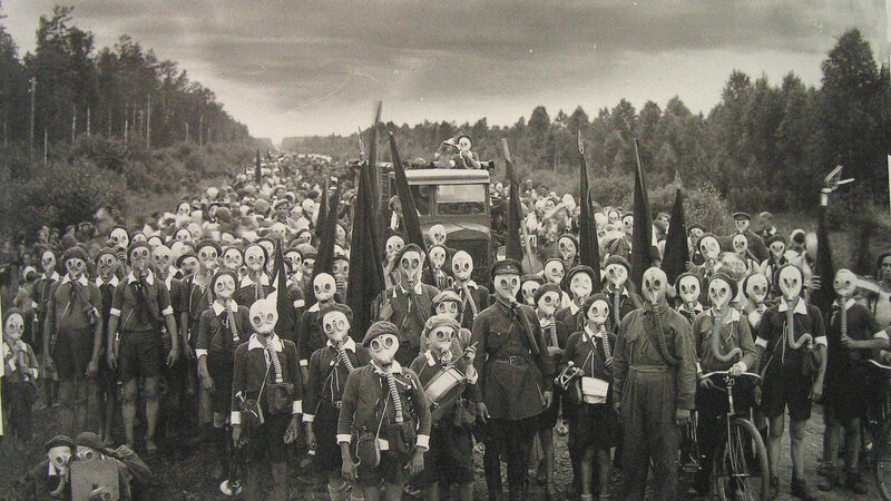 Crowd in gas masks on road