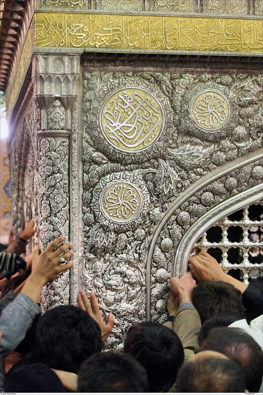 Crowd touching ornate shrine