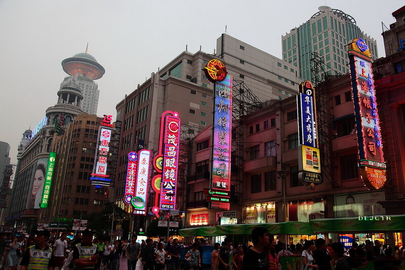 Crowded Street with Neon Signs