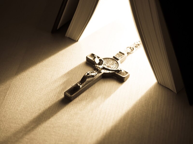 Crucifix in sunlight between books