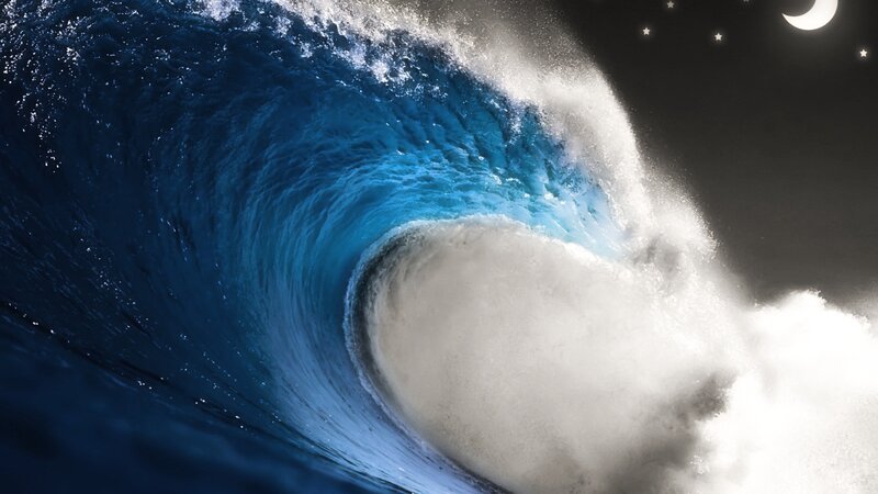 Curling ocean wave at night