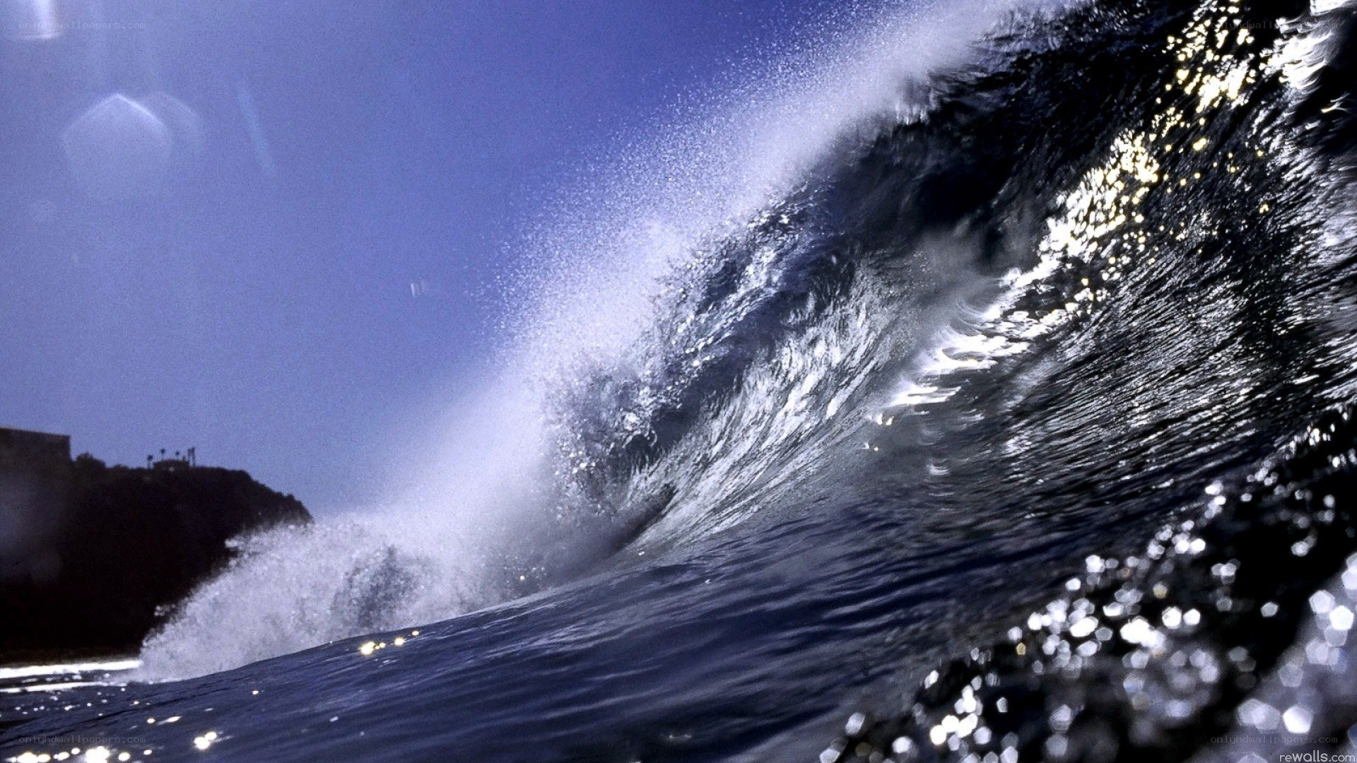 Curling ocean wave at sunset