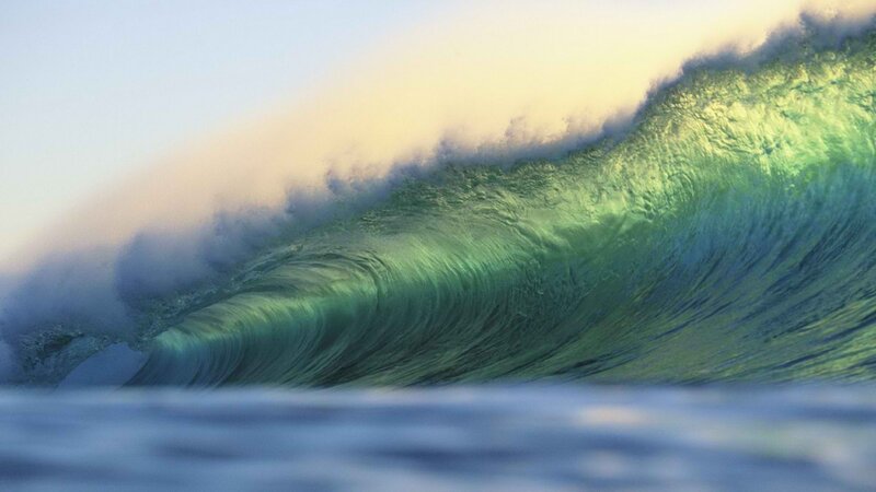 Curling ocean wave at sunset