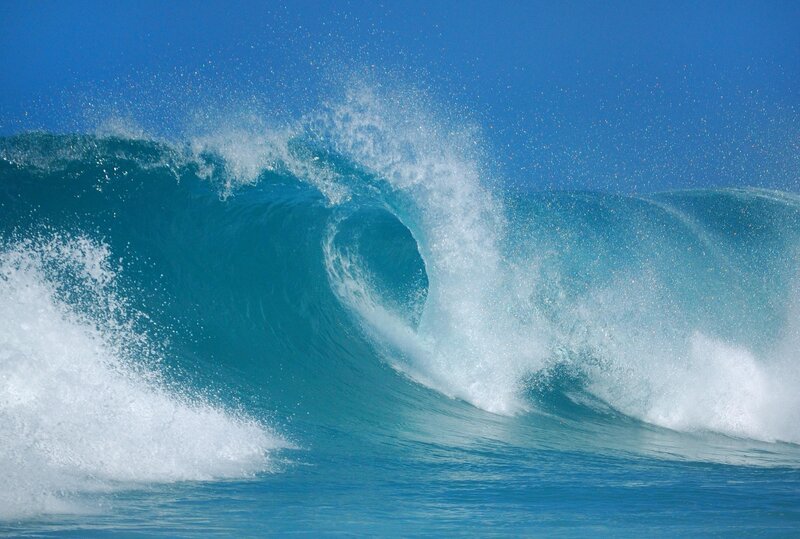 Curling ocean wave in blue sky