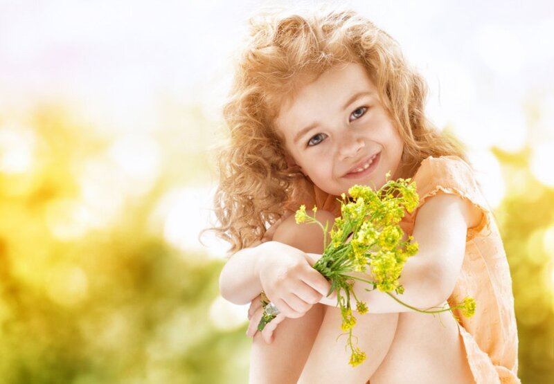 Curly-haired Girl Holding Flowers