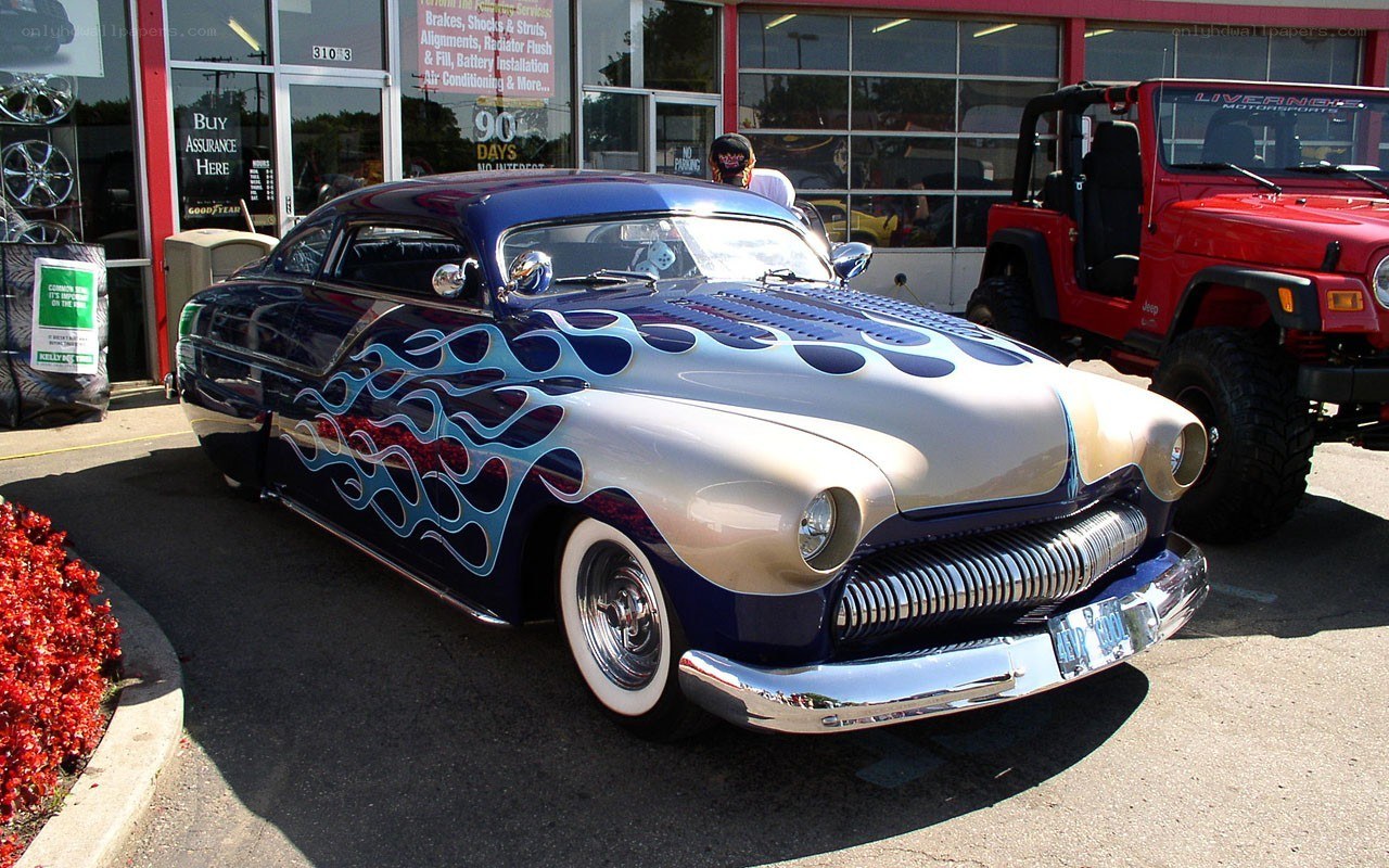 Custom flame-painted car at auto shop